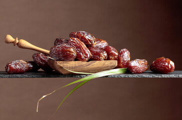  Closeup sweet dried dates in wooden dish.