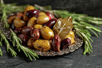 Spicy olives in a silver dish.