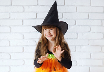 Funny Little Girl In A Witch Costume For Halloween. Happy Halloween! Cute smiling little girl in a...