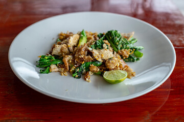 Fried noodle with egg and kale on white dish