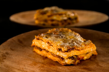 Lasagna or lasagne Bolognese on a wooden dish