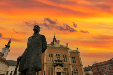 Novi Sad square, novi sad church and municipality building with sunset clouds and colors - obrazy, fototapety, plakaty