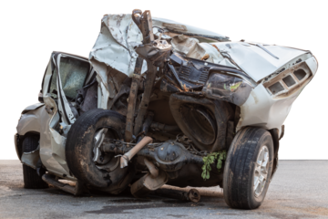 The isolate on the back of a white car was demolished in an accident and severely collided with a roadside tree as it rains, slipping wet roads, which is dangerous.