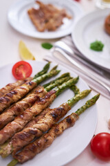 Tasty breakfast - Asparagus wrapped with bacon and spices on a plate