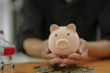 ฺBusinessman  saving money by putting a coin into piggy bank concept saving money for finance accounting  