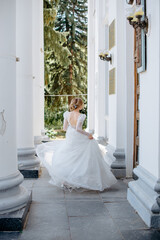 Fototapeta premium a young bride in a wedding dress dances standing with her back
