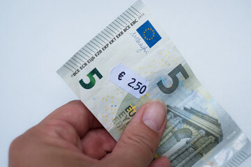 Five euro banknote with 2 euro 5 cent price tag. Selective focus on label. Inflation in Europe, hyper inflation, devaluation of fiat money concept. - obrazy, fototapety, plakaty