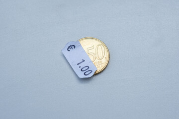 50 cent euro coin with one euro price tag. Selective focus on label. Inflation in Europe, hyper...
