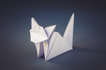 White paper cat origami isolated on a grey background