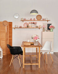 White kitchen interior in loft style. Shelves with pink crockery and kitchen utensils. Studio apartment. Rent and delivery of housing. Hostel and hotel