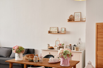 Obraz na płótnie Canvas White kitchen interior in loft style. Shelves with pink crockery and kitchen utensils. Studio apartment. Rent and delivery of housing. Hostel and hotel
