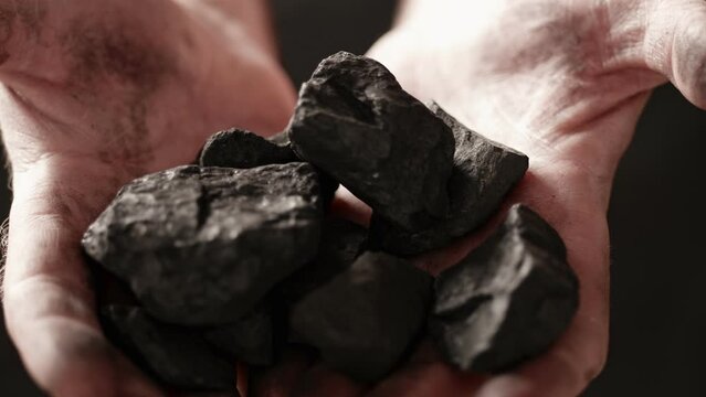 Coal in the hand of a miner.uggets of coal in his hands.Coal in the hand of a miner.