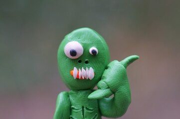 A toy zombie makes a phone gesture. Ideas for Halloween.