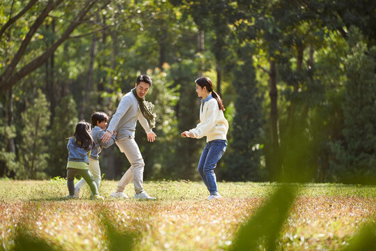 young asian family with two children enjoying outdoor activity