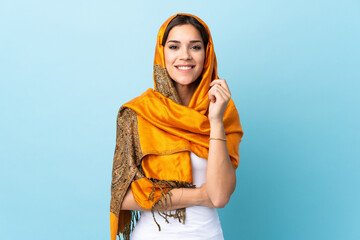 Young Moroccan woman with traditional costume isolated on blue background laughing