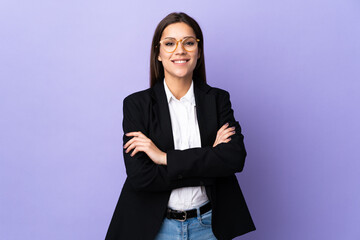 Business woman isolated on purple background keeping the arms crossed in frontal position