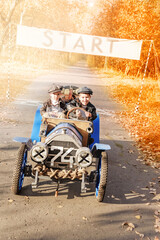Young happy children. Little funny boys in the form of racers began to play as a team on an old racing car in the autumn park. Art photography of kids in retro style. - 528005704