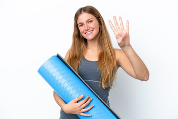 Young sport woman going to yoga classes while holding a mat happy and counting four with fingers