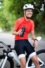 Rennradfahrer, sportliche Frau in Fahrradkleidung und mit Helm beim Sport