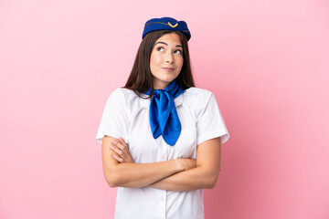 Airplane stewardess Brazilian woman isolated on pink background making doubts gesture while lifting the shoulders