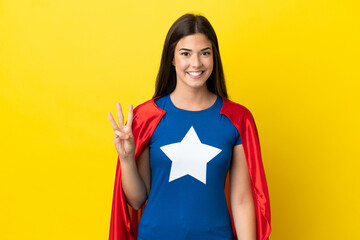 Super Hero Brazilian woman isolated on yellow background happy and counting three with fingers