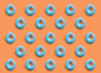 Collage and background of donuts covered with colorful sprinkles on a orange background.