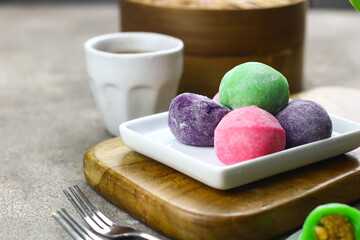 Mochi cakes one of Japanese traditional rice cake. Assorted color with different filling. Selective focus, grey grainy background.