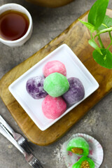 Mochi cakes one of Japanese traditional rice cake. Assorted color with different filling. Selective focus, grey grainy background.
