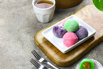 Mochi cakes one of Japanese traditional rice cake. Assorted color with different filling. Selective focus, grey grainy background.