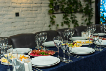beautifully laid tables with glasses, appliances and appetizer in restaurant