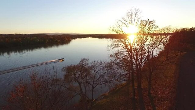 Arial view of boat on rover in Arkansas during fall foliage near Spadra recreation boating area of clarksville AR near sunset   