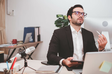 Fototapeta premium Businessman, Confident Male executive commuter is looking at hand held digital tablet screen. Confident professional making successful plan while working on laptop at office.