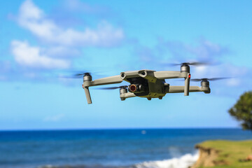 Small high tech drone flying in front of blue sky