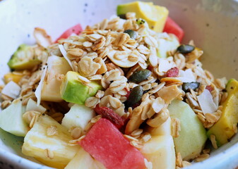 mixed fruit with granola on white bowl