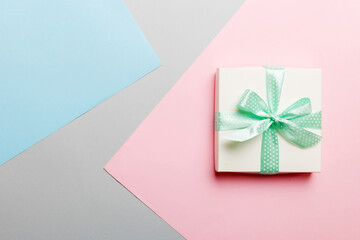 holiday handmade white present tied green ribbon bow top view with copy space. Flat lay holiday background. Birthday or christmas present. Christmas gift box concept with copy space
