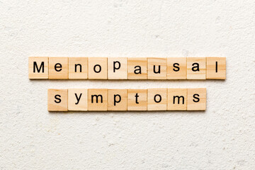 menopausal symptoms word written on wood block. menopausal symptoms text on cement table for your desing, concept