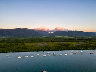 Aerial photo of perfect blue water, sunset sky and boats docked