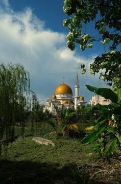 Selective focus picture of golden dome and minerat of a mosque at Klang riverside with tree insight.
