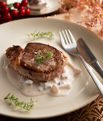 Beef tenderloin with mushroom sauce and cheese.