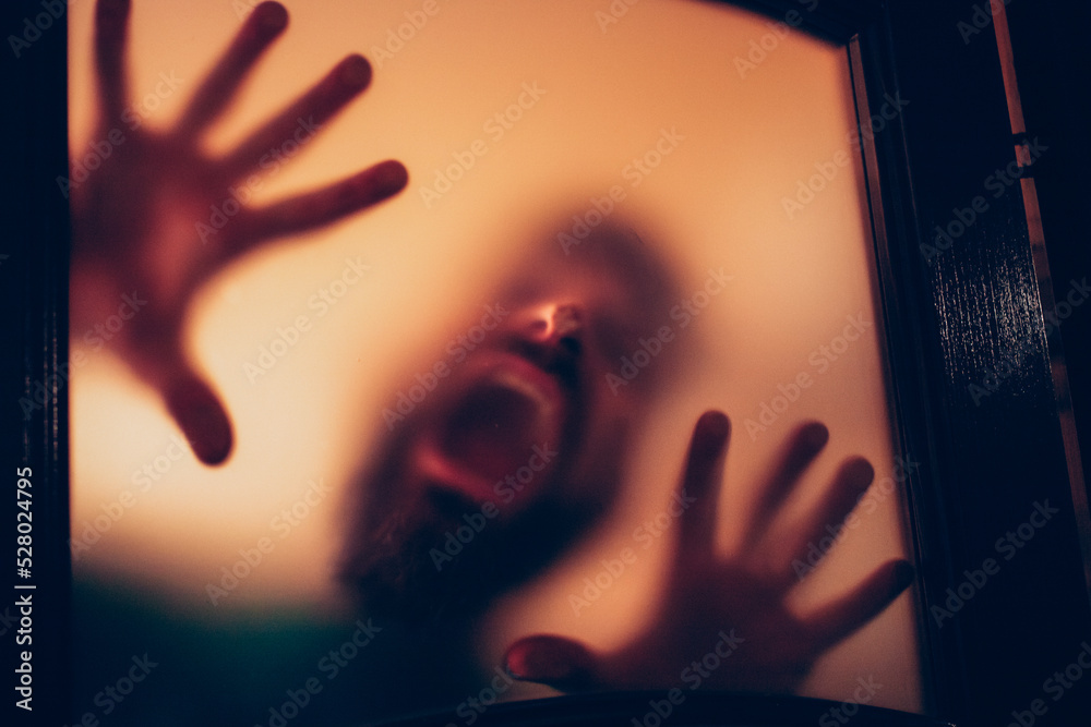 Wall mural scary picture of hands behind glass, horror ghost woman behind door, Halloween  concept