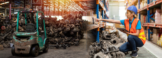 Asian woman worker working at old motor automotive spare parts warehouse. Woman warehouse worker...