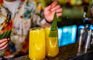 bartender making cocktail with passion fruit in a nightclub bar