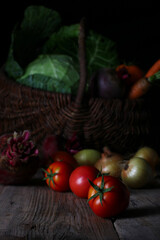 harvest vegetables from the garden laid out on a table with a wicker basket	