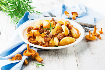 Potatoes with Chanterelle Mushrooms and Rosemary on White Wooden Background