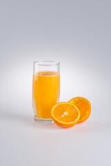 Glass of orange juice and  peel from orange on a white background