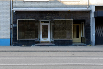 abandoned shop in the urban city near sidewalk, empty store with glass front.