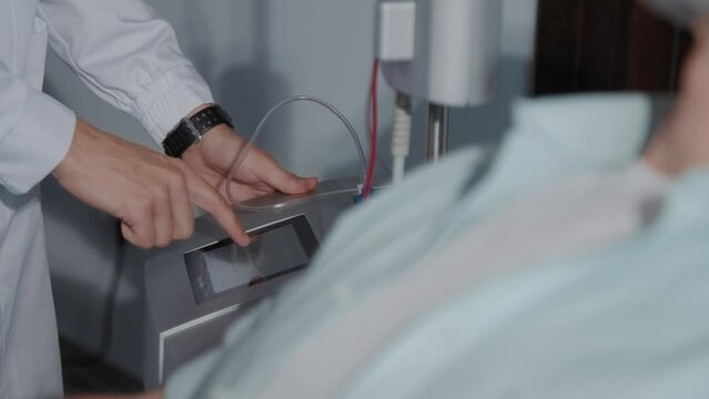 In modern clinic close up hands female nurse use machine for blood. Man donates blood. Medicine. In hospital room. Healthcare. Slow m otion
