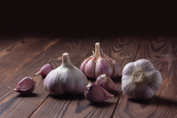 Garlic cloves and bulb on wooden table. Fresh peeled garlics and bulbs.
