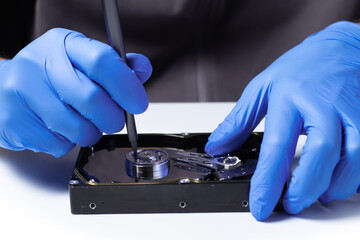 Repair Hard disk. Hands of master in gloves with screwdriver repair the computer hard drive.
