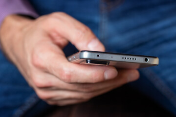 A man hold in hand and using smartphone. Close up